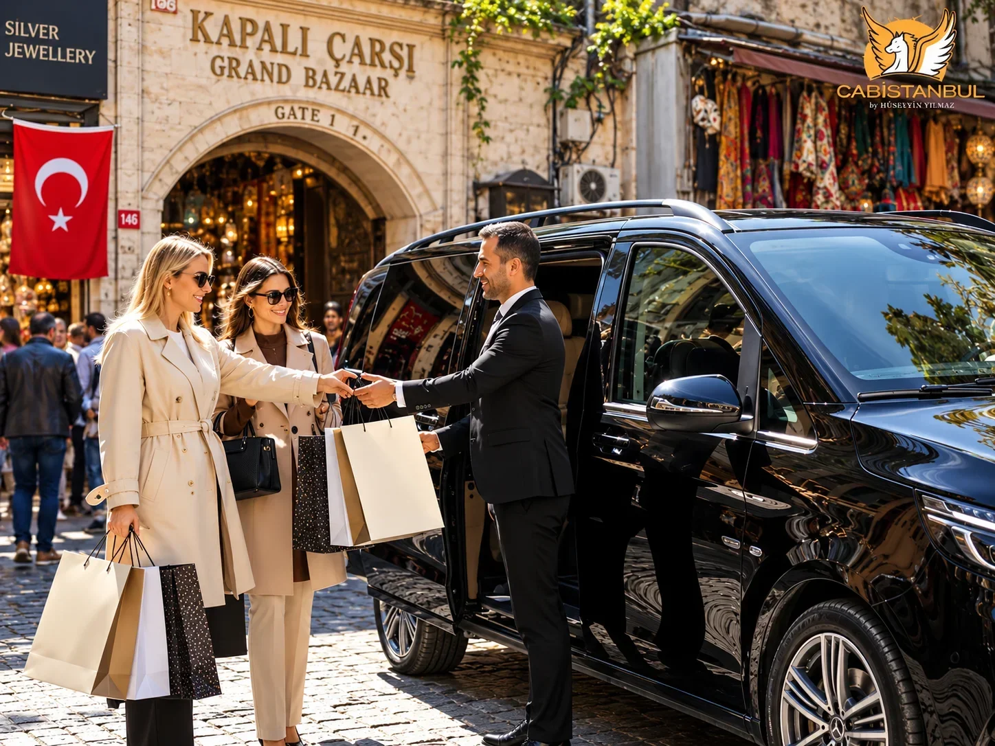 Cab Istanbul司机身着深色西装，在伊斯坦布尔大巴扎1号门前帮助两位旅客把购物袋放上黑色奔驰Vito